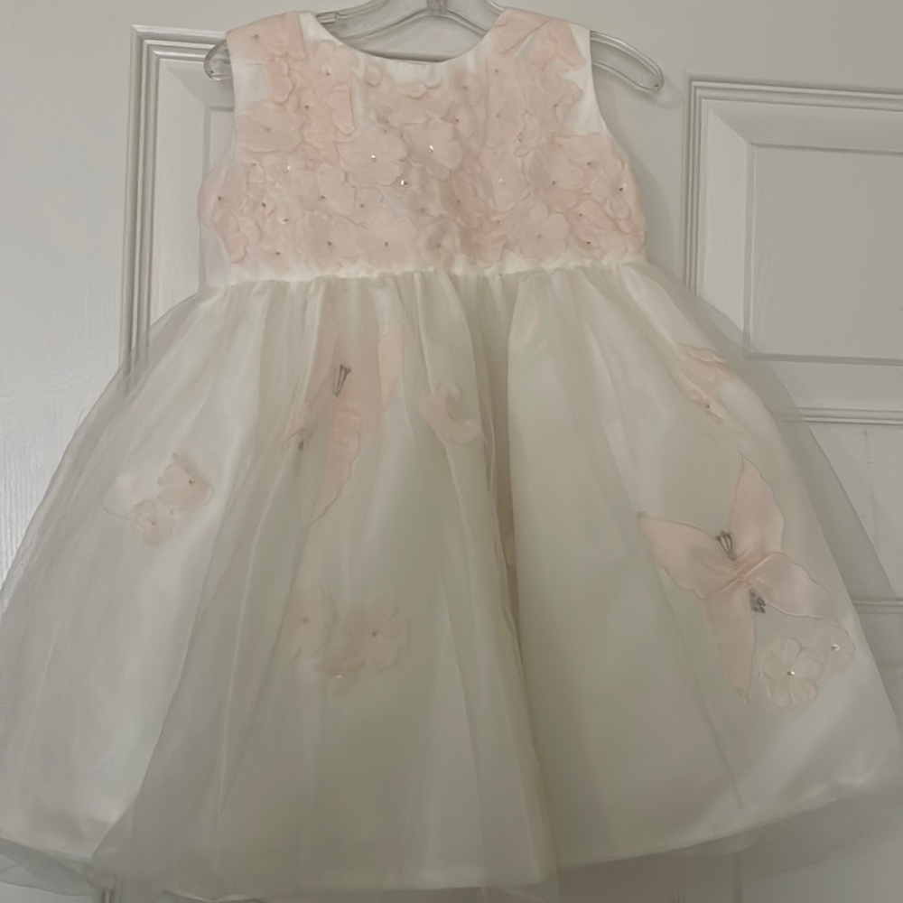Beautiful toddler dress with intricate flower cutout and beaded detail.